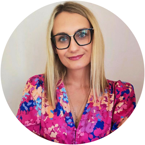 Aleksandra Nikiel, psycholog pracująca w centrum psychologicznym w Warszawie, w różowej, wzorzystej bluzce i okularach.