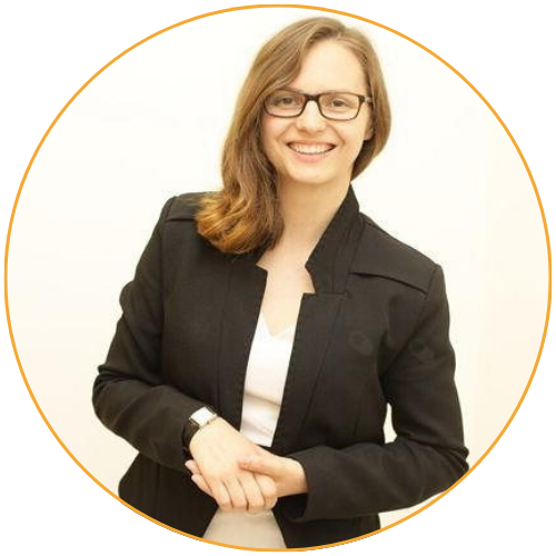 Uśmiechnięta Klara Sztyler-Małek, psycholog w centrum psychologicznym w Warszawie, w czarnej marynarce na jasnym tle.