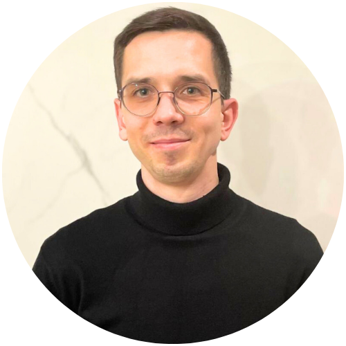 Tomasz Hecman, psycholog z centrum psychologicznego w Warszawie, w czarnym golfie i okularach, na jasnym tle.